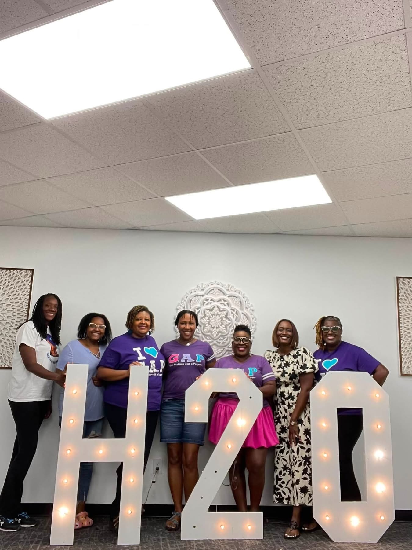 GAP board members at a planning retreat with H2O marquee letters